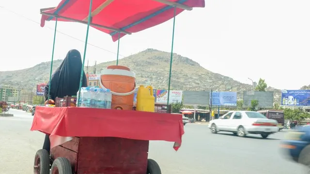 In Armut und schwarzem Gewand: Die Straßenverkäuferin von Kabul